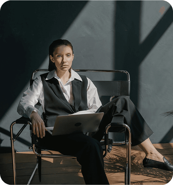 Girl in a suite sitting on a chair.